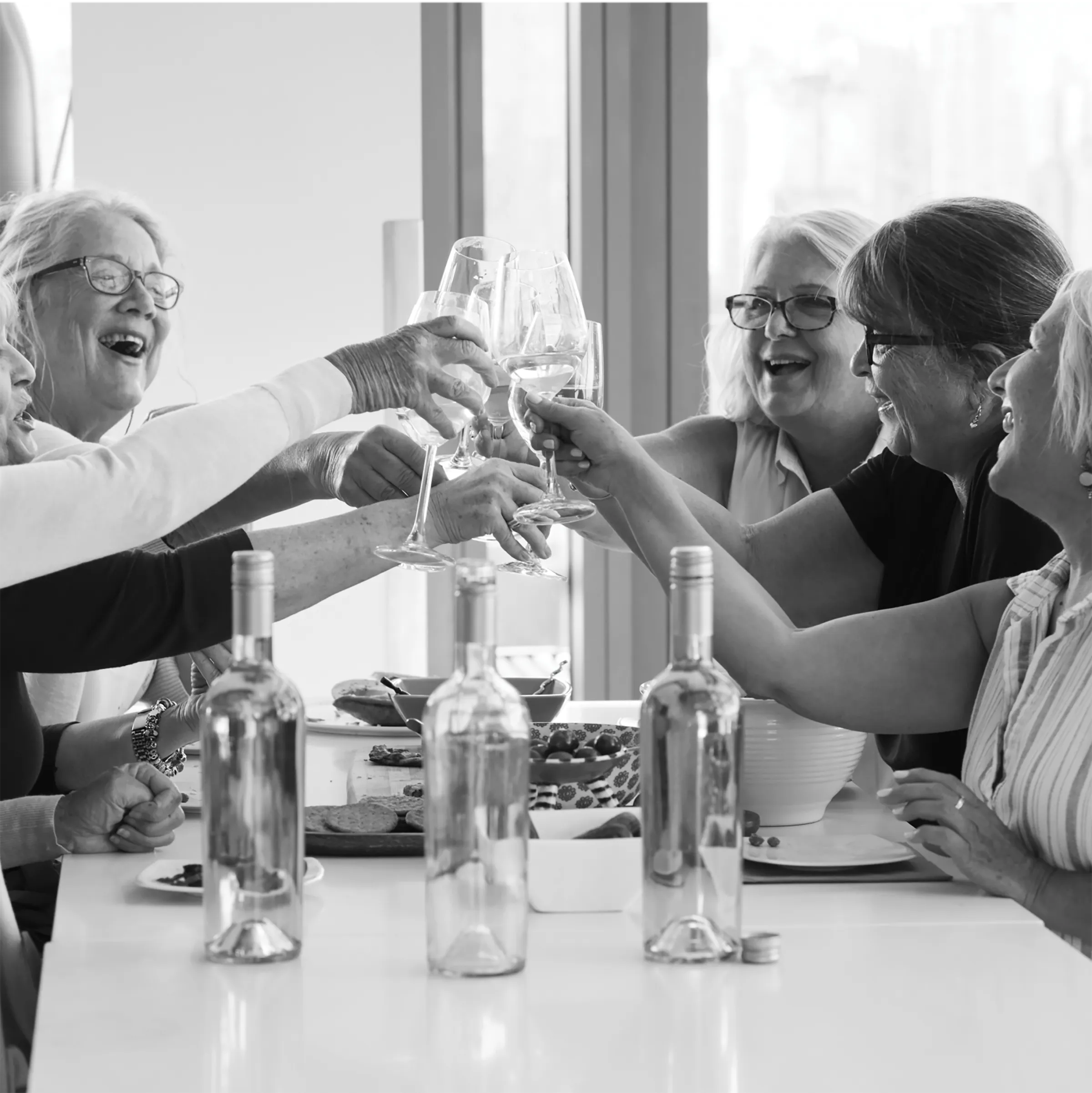 A group of female residents at The Reserve raising their glasses of wine together.